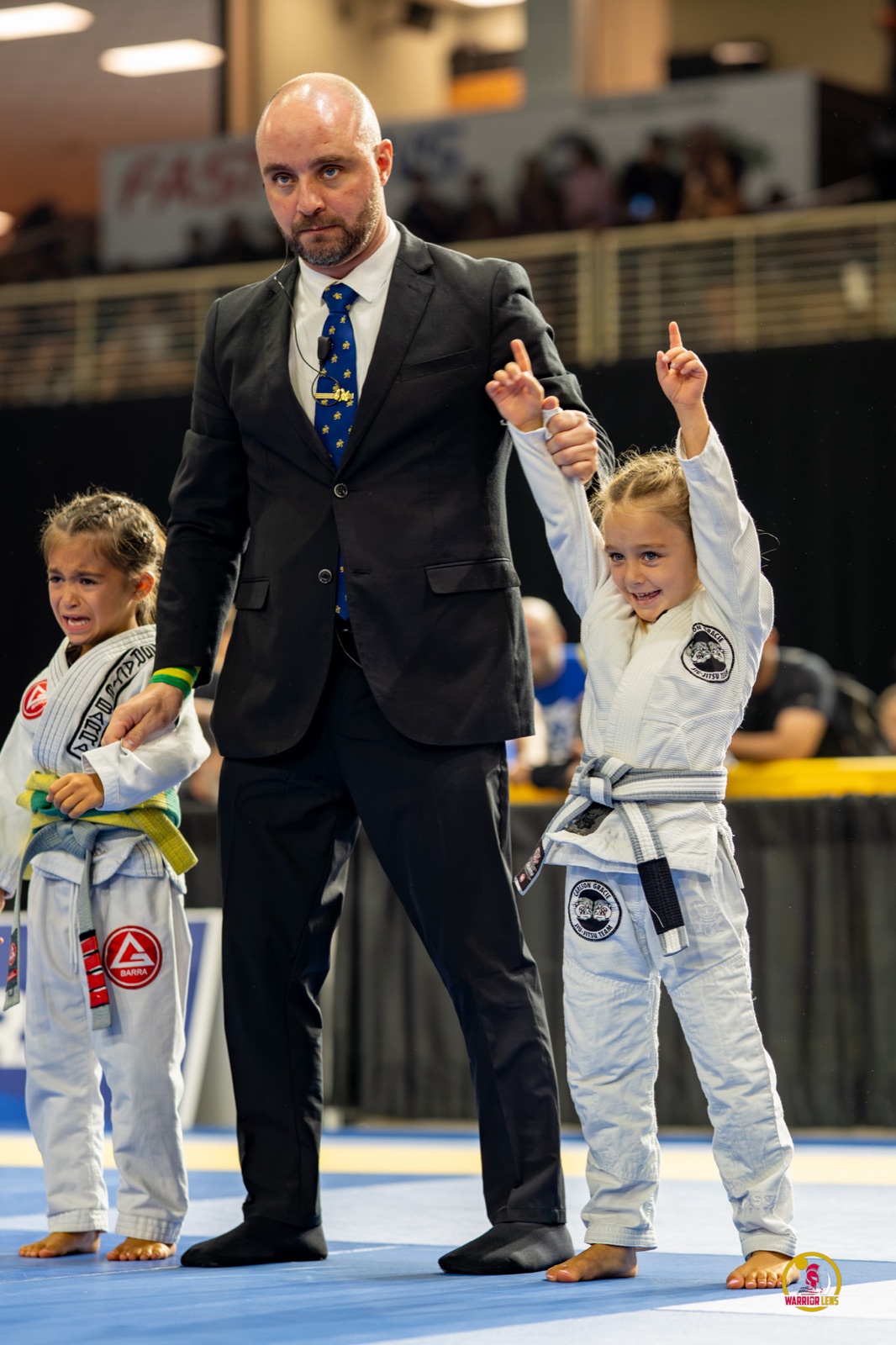 A young Carlson Gracie student having her hand raised after winning her match